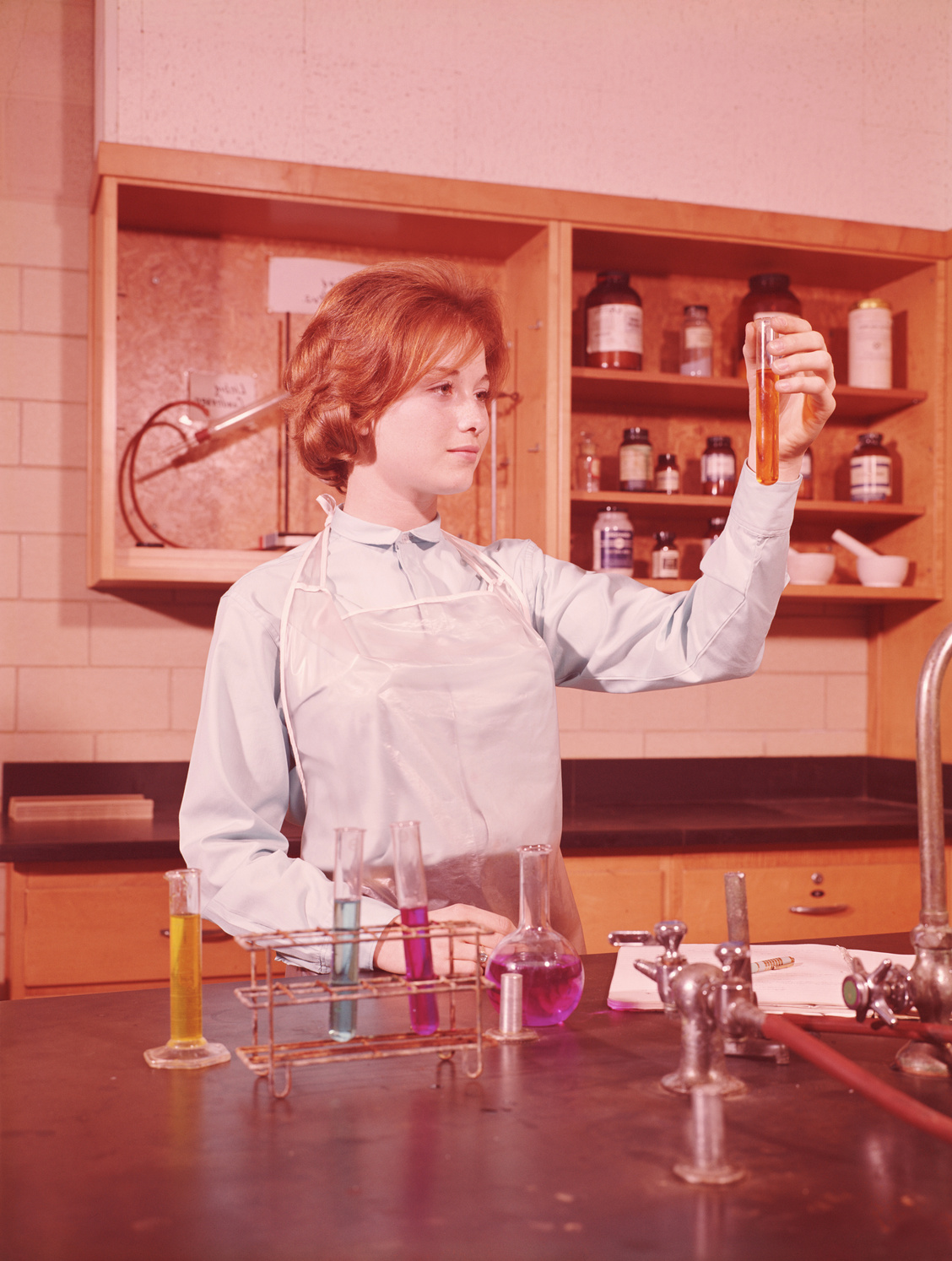 Teenage female student holing up test tube in chemistry laboratory. (Photo by H. Armstrong Roberts/Retrofile/Getty Images)